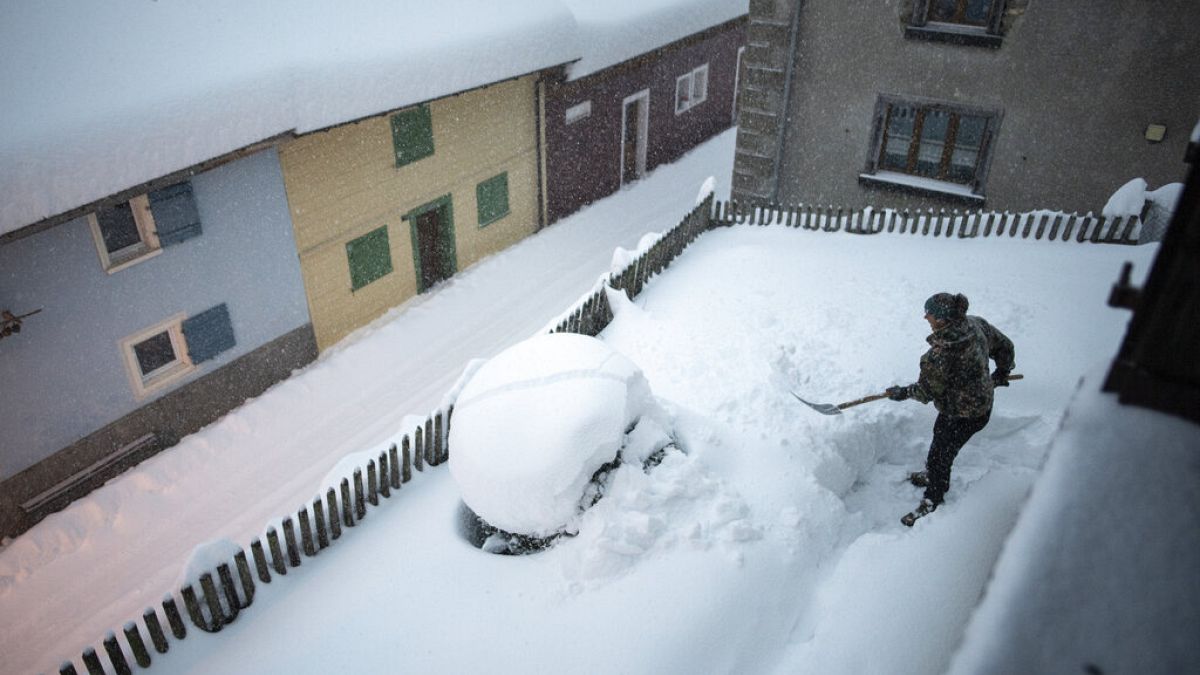 Frau beim Schippen von Schnee in Valens in der Schweiz