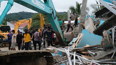 Los equipos de rescate buscan sobrevivientes entre las ruinas de un edificio dañado por un terremoto en Mamuju, West Sulawesi, Indonesia, el viernes 15 de enero de 2021