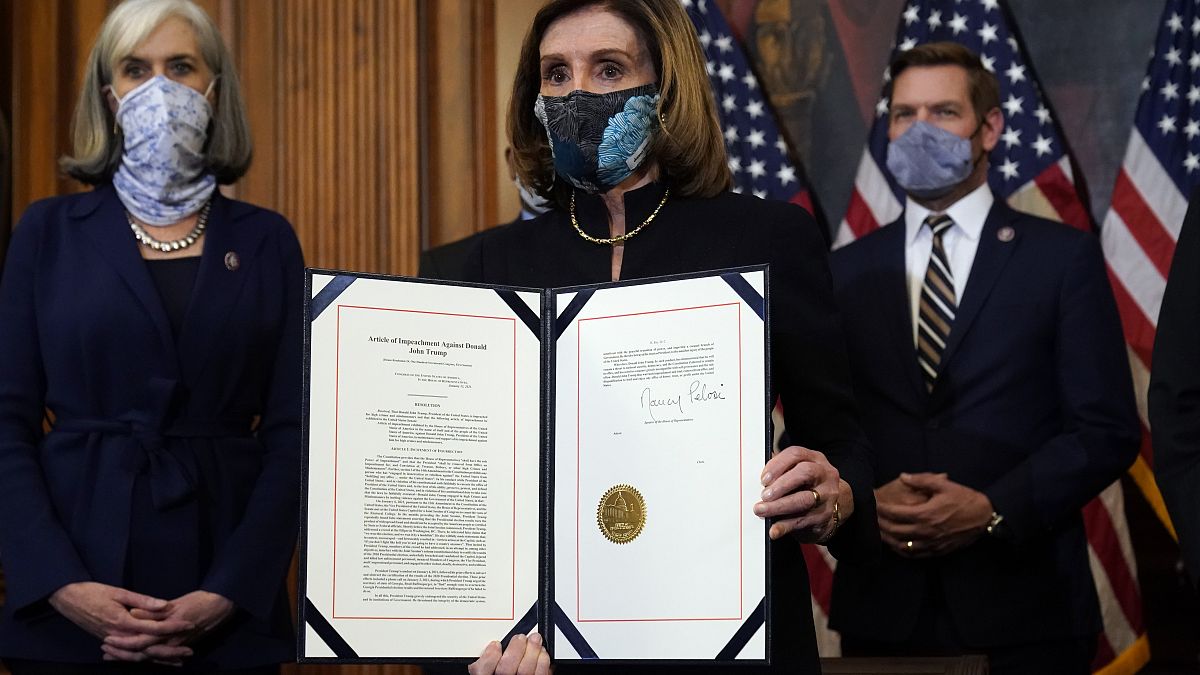 La presidenta de la Cámara de Representantes, Nancy Pelosi, muestra el artículo de impeachment firmado contra Donald Trump  en el Capitolio, en Washington, el 13 de enero.