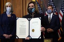 House Speaker Nancy Pelosi displays the signed article of impeachment against President Donald Trump