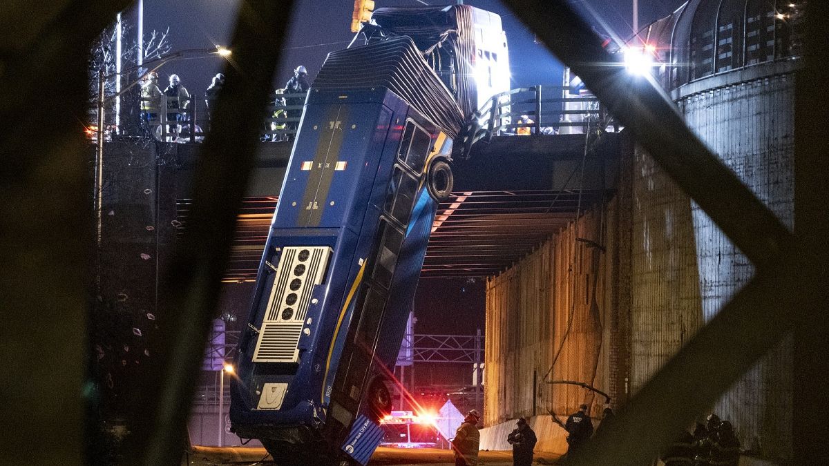A bus in New York City which careened off a road in the Bronx neighborhood of New York is left dangling from an overpass Friday, Jan. 15, 2021.