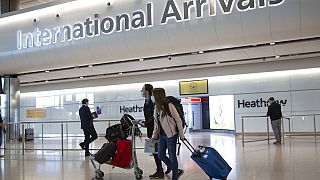 A sign at Heathrow Airport Terminal 5 arrivals warns of Coronavirus, in London, Tuesday, March 24, 2020