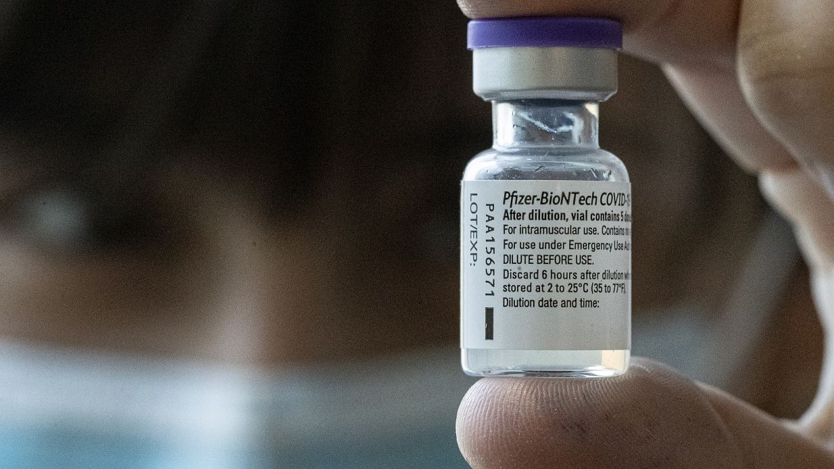 A medical worker holds up a vial of the Pfizer-BioNTech COVID-19 vaccine while applying a second dose to health workers in Santiago, Chile, Friday, Jan. 15, 2021.