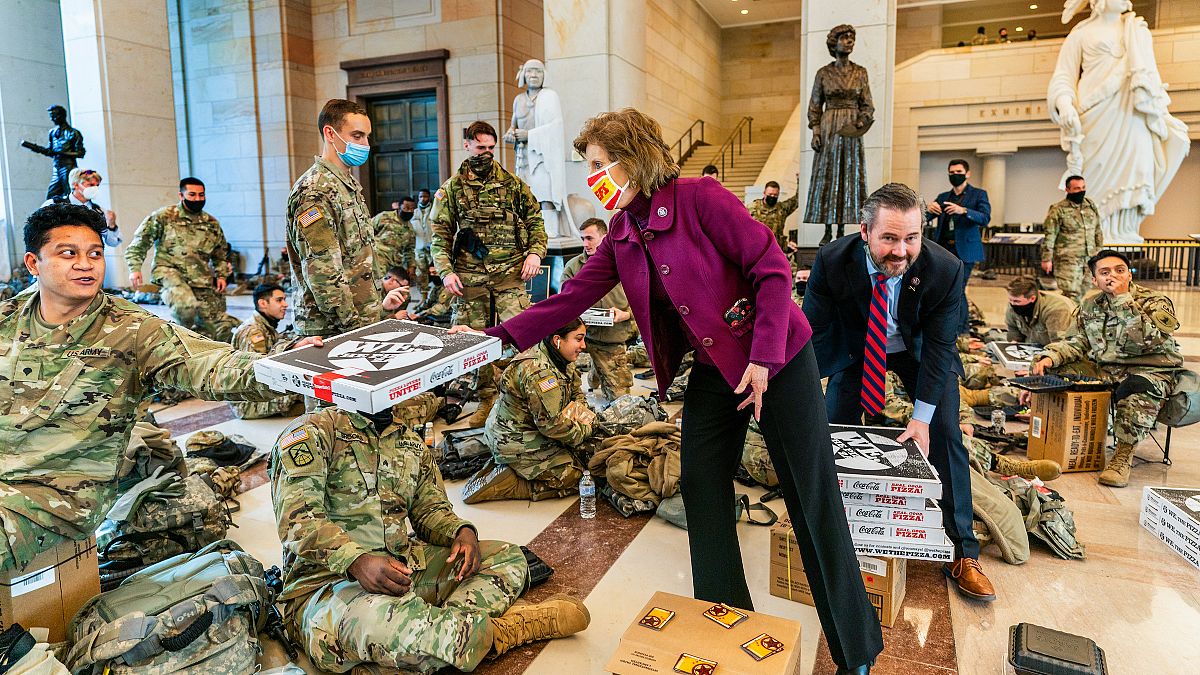 Pizzas are handed out to members of the National Guard gathered at the Capitol Visitor Center in Washington, USA, during the vote to impeach President Donald Trump. January 13