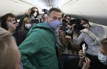 lexei Navalny is surrounded by journalists inside the plane prior to his flight to Moscow in Berlin Brandenburg Airport, Germany. Sunday, Jan. 17, 2021.