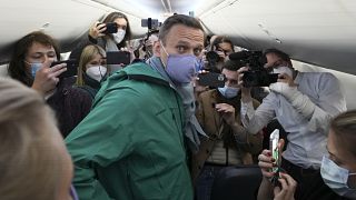 lexei Navalny is surrounded by journalists inside the plane prior to his flight to Moscow in Berlin Brandenburg Airport, Germany. Sunday, Jan. 17, 2021.