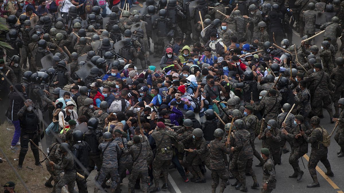 Soldaten drängten die Menschen aus Honduras an einer Autobahn-Sperre zurück