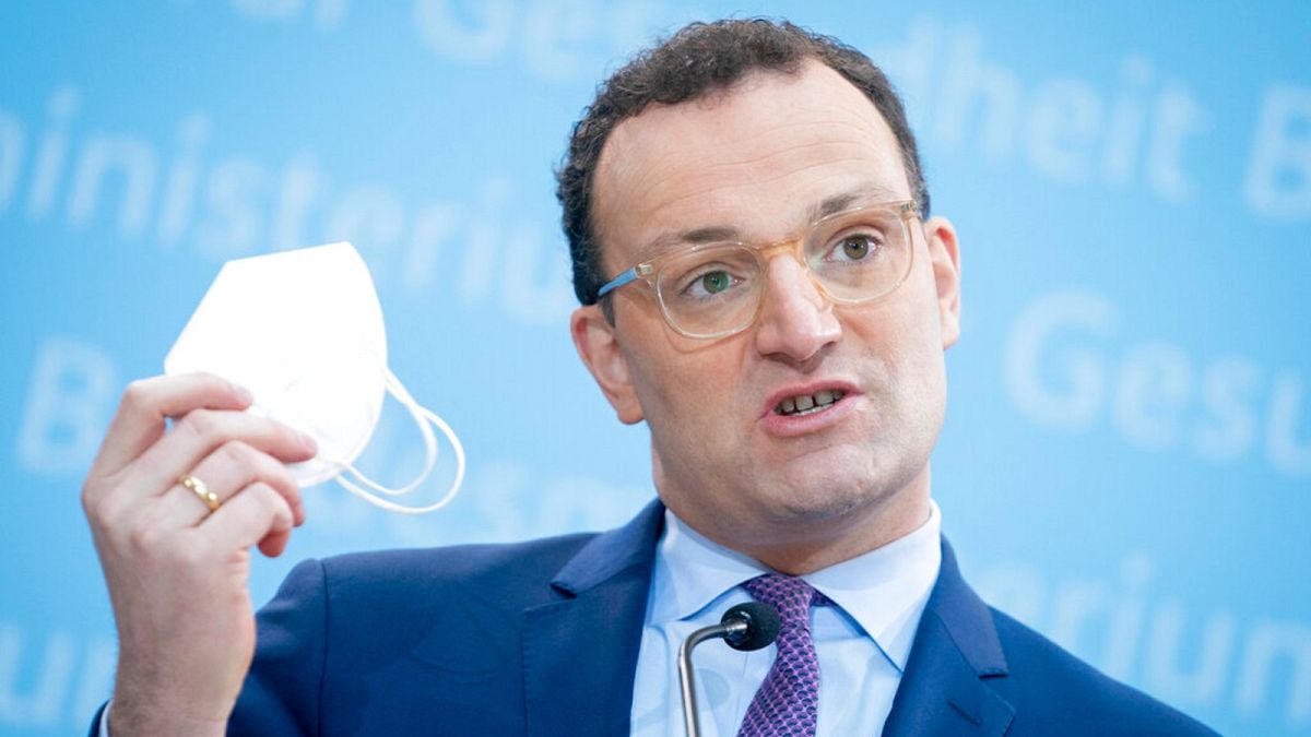 German Health Minister Jens Spahn shows his FFP2 face mask during a press conference in Berlin, Germany, Monday, Jan. 18, 2021