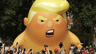 In this July 13, 2018 photo a six-meter high cartoon baby blimp of U.S. President Donald Trump is flown as a protest against his visit, in Parliament Square in London, UK.