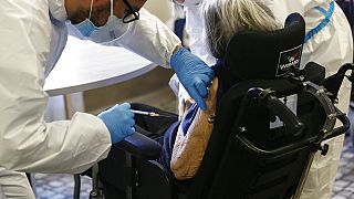 Medical personnel administer a dose of the Pfizer-Biotech vaccine to an elderly woman in a nursing home, in Rome