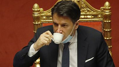 Italian premier Giuseppe Conte sips a coffee during a debate at the Senate prior to a confidence vote, in Rome, Tuesday, Jan. 19, 2021
