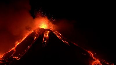 Mount Etna with explosions at top and lava streaming down the sides