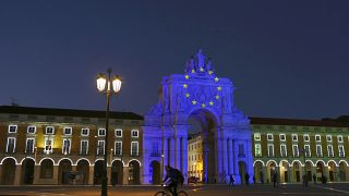The arch at Lisbon's Comercio square is illuminated to mark the start of the Portuguese Presidency of the Council of the European Union, Friday, Jan. 1, 2021.