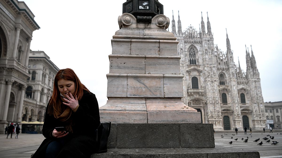 امرأة تدخن سيجارة في ساحة بيازا ديل دومو في ميلانو  