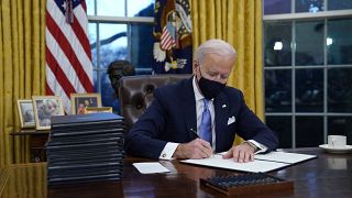 President Joe Biden signs his first executive order in the Oval Office of the White House on Wednesday, Jan. 20, 2021, in Washington.