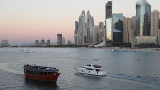 Tourists on a yacht pass a traditional show in Dubai, United Arab Emirates, Tuesday, Jan. 12, 2021.