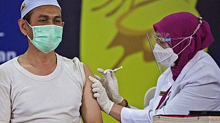 Endonezya'da bir din adamı koronavirüs aşısı olurken