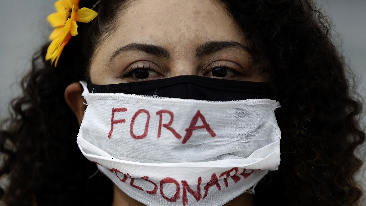 Διαδηλώτρια κατά του Μπολσονάρο στη Βραζιλία, μία από τις χώρες με θλιβερό ρεκόρ κρουσμάτων και θανάτων Covid-19