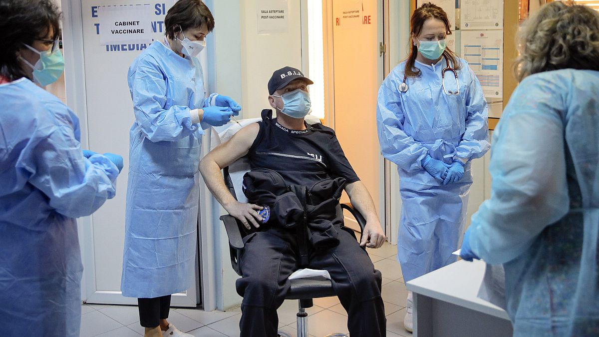 In this photo taken on Friday, Jan. 15, 2021 a Romanian gendarme gets a COVID-19 vaccine at a hospital in Bucharest, Romania.