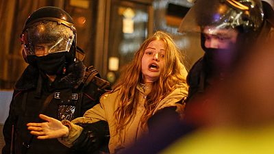 Agentes antidisturbios se llevan detenida a una joven manifestante en Moscú