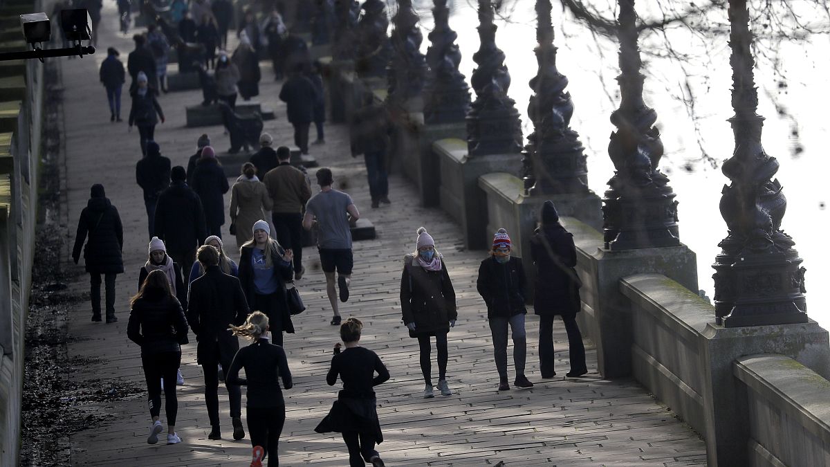 People exercise along the bank of the River Thames in London, Saturday, Jan. 23, 2021 during England's third national lockdown.