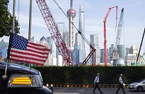 Sanghaj látképe, az előtérben egy amerikai követségi autó orrával