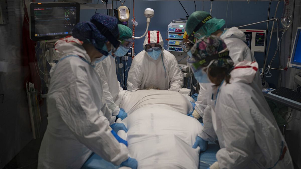 Varios sanitarios se preparan para rotar a un paciente de COVID en el Hospital del Mar, en Barcelona