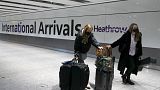 Travellers arrive at Heathrow Airport in London.