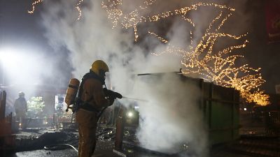 Un bombero apaga un contenedor de basuras incendiado en Róterdam (25/01/21)
