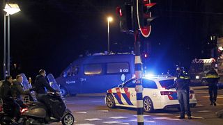 A police officers speaks to youths on scooters at a road block during a nation-wide curfew in Amsterdam, Netherlands, Tuesday, Jan. 26, 2021.