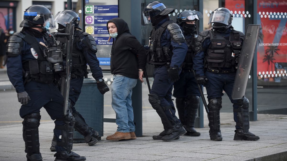 عناصر من الشرطة الفرنسية يعتقلون شخصاً في منطقة رين غربي البلاد