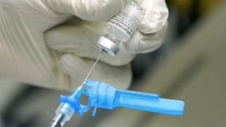 A registered nurse prepares a syringe with the Pfizer COVID vaccine.