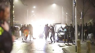 In this grab taken from video on Monday, Jan, 25, 2021, rioters throw stones at police, in Haarlem, Netherlands