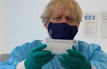 UK Prime Minister Boris Johnson with COVID-19 swab samples at Queen Elizabeth University Hospital in Glasgow.