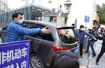 A car that's part of a convoy carrying the World Health Organization team of researchers arrives at the Hubei Province Xinhua Hospital in Wuhan on Friday, Jan. 29.