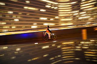 A cyclist, wearing a face mask to prevent the spread of the coronavirus COVID-19, rides a bicycle past the EU headquarters in Brussels