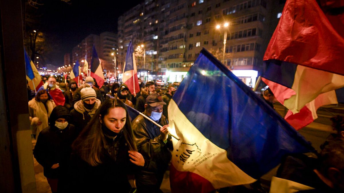 Protesters waving flags march after a deadly fire at a hospital treating COVID-19 patients in Bucharest, Romania, Saturday, Jan. 30, 2021. 