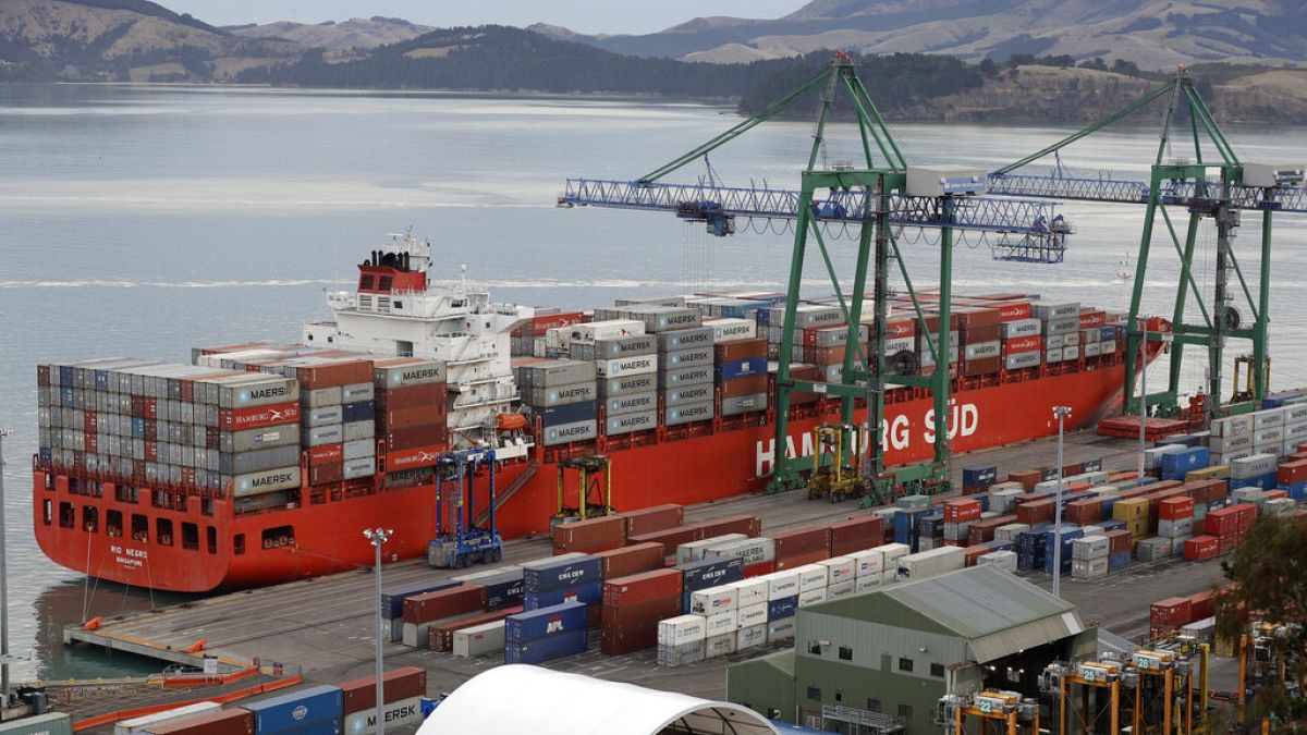 In this June 3, 2020, photo, containers are loaded onto a ship for export at Lyttelton Port near Christchurch, New Zealand.
