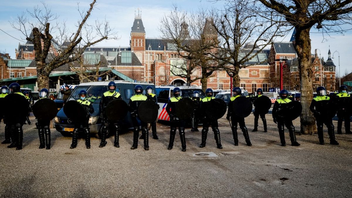Police officers stand in line on the Museumplein in Amsterdam as Nederland in Verzet action group called for a protest against the Covid-19 guidelines