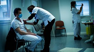 A health worker receives the coronavirus vaccine at a hospital in Liege, Belgium