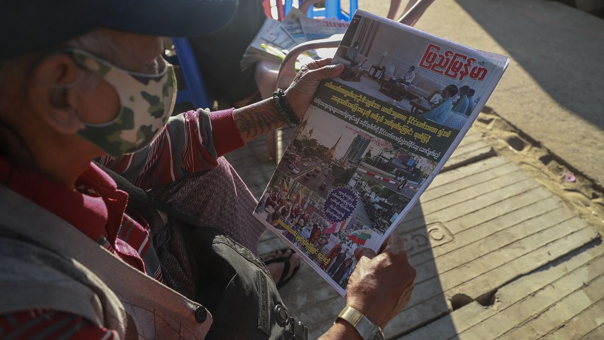 Un hombre lee en un periódico el anuncio de los militares en la capital birmana