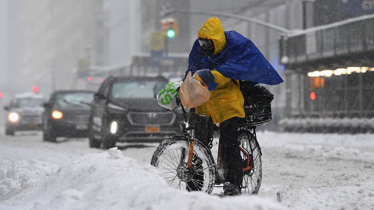 Un livreur à vélo tente de poursuivre son activité à New-York malgré la tempête de neige