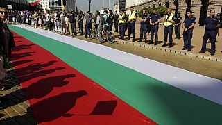 Protestors' shadows are cast on a giant Bulgarian flag amid demonstrations in Sofia demanding the government's resignation