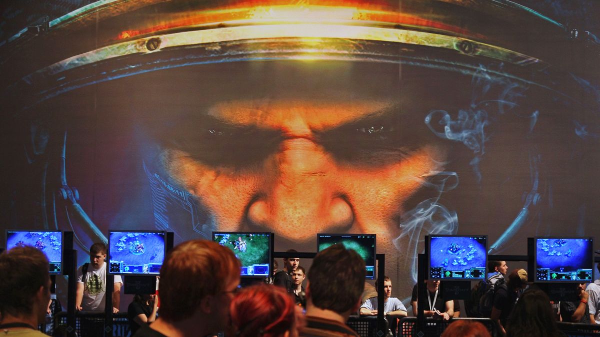 Les visiteurs regardent le jeu StarCraft au stand de Blizzard Entertainment à la Games Convention de Leipzig, en Allemagne, le 23 août 2007. 