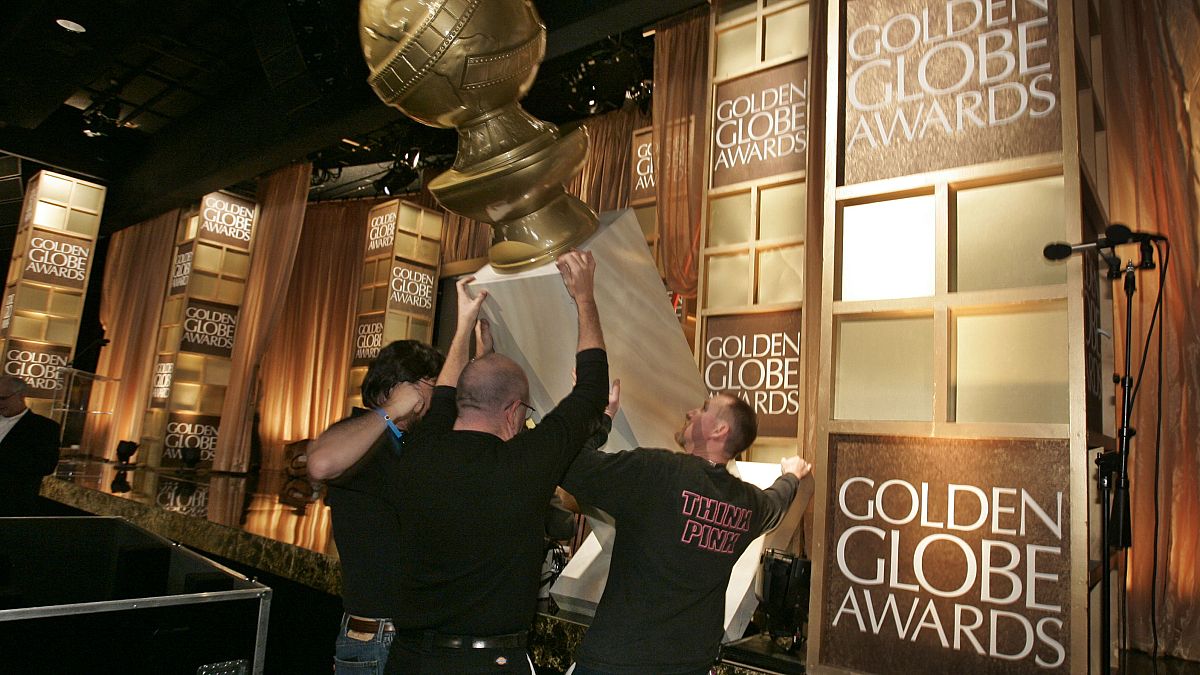 عمال يضعون جائزة غولدن غلوب على منصة المؤتمر الصحفي لإعلان الفائزين بجوائز غولدن غلوب السنوية الـ 65 في بيفرلي هيلز، كاليفورنيا.