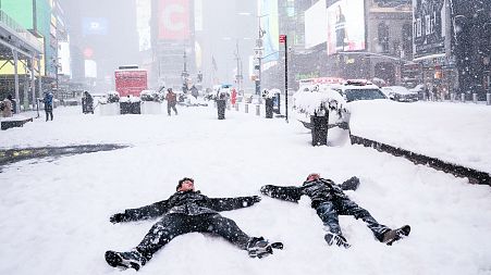 People make 'snow angels' during a snowstorm in Times Square, New York City
