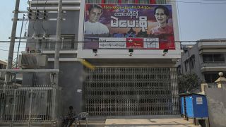 أبواب مغلقة لمكتب حزب الرابطة الوطنية من أجل الديمقراطية، ولافتة لأونغ سان سو كي، في ماندالاي، ميانمار.