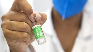 Una enfermera muestra la etiqueta de la vacuna de Astrazeneca y la Universidad de Oxford