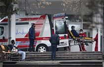 In this picture taken on Tuesday, Dec. 29, 2020, health workers wheel out a patient from an ambulance, at the entrance of the University Clinic complex in Skopje, North Macedo