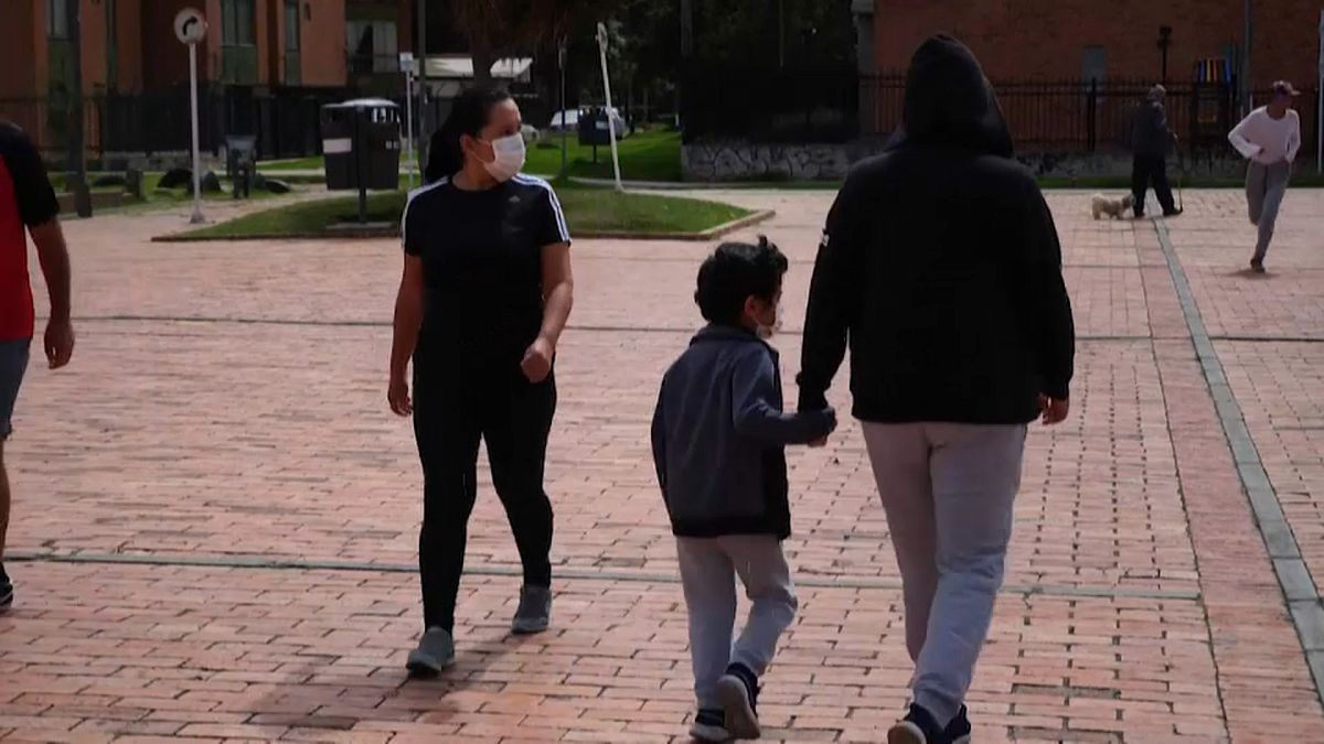 Una madre y su hijo caminan por la calle en Colombia